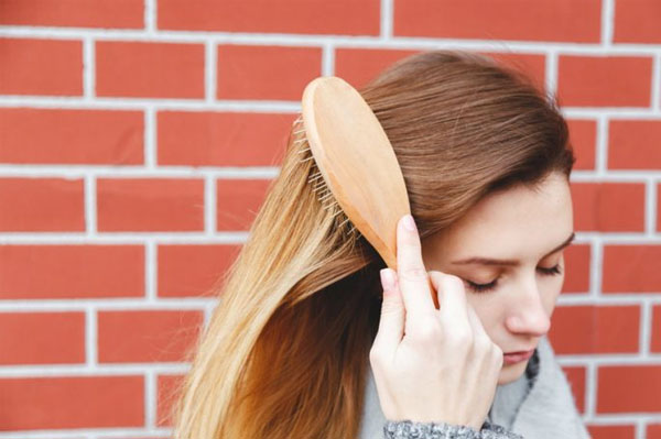 Femme qui se brosse les cheveux